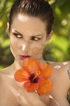 Royalty Free Photo of an Attractive Tattooed Woman Holding Hibiscus Flowers in Maui, Hawaii, USA