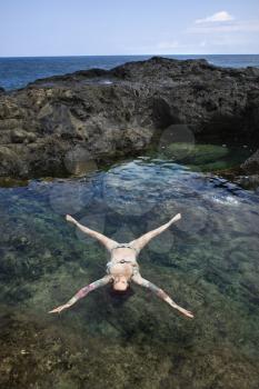 Royalty Free Photo of a Sexy Woman in a Bikini Floating in a Tidal Pool in Maui, Hawaii, USA