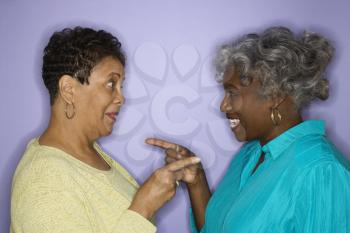 Royalty Free Photo of Older African American Females Pointing at Each Other