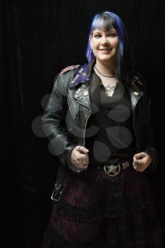 Royalty Free Photo of a Woman With Blue Hair and Black Leather Jacket Standing Against a Black Background