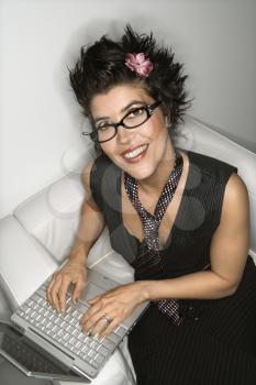 Royalty Free Photo of a Woman Smiling and Typing on a Laptop