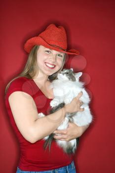 Royalty Free Photo of a Woman Wearing a Cowboy Hat Holding a Cat