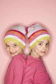 Royalty Free Photo of Young Female Twin Children Standing Back to Back