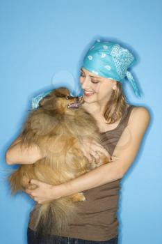 Royalty Free Photo of a Teen Girl Holding a Pomeranian Dog