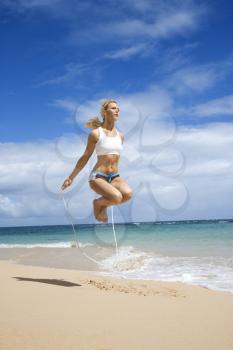 Royalty Free Photo of a Woman Jumping Rope on a Beach