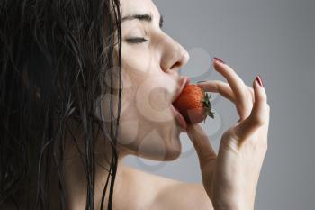 Royalty Free Photo of a Topless Woman Biting a Strawberry