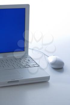 Royalty Free Photo of a Laptop Computer with Blue Screen and Mouse