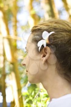 Royalty Free Photo of a Woman Wearing a Plumeria Flower Behind Her Ear