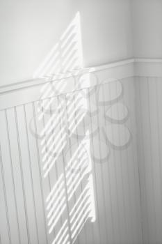 Royalty Free Photo of a Sun Spot on a Wall From Light Shining Through Window Blinds