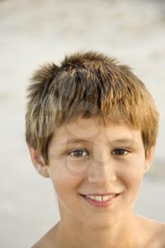 Royalty Free Photo of a Smiling Boy Standing on a Beach
