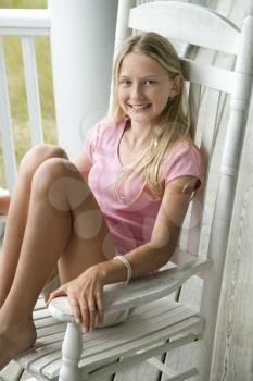 Royalty Free Photo of a Girl Sitting in a Chair Smiling