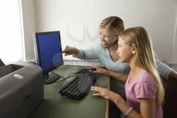 Royalty Free Photo of a Woman and Preteen Girl Using a Laptop Computer