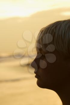 Royalty Free Photo of a Profile Boy on a Beach at Sunset