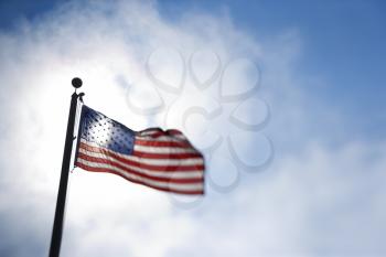 Royalty Free Photo of an American Flag Blowing in the Breeze Against a Blue Sky