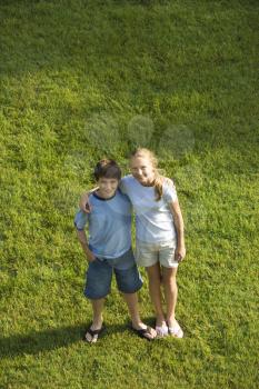 Royalty Free Photo of a Boy and Girl Standing on a Lawn Together