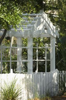 Royalty Free Photo of a Garden Arbor With White Picket Fence