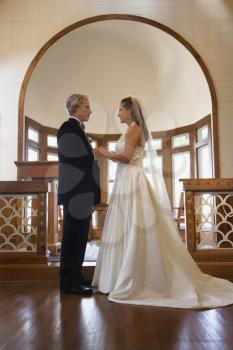 Royalty Free Photo of a Bride and Groom at the Alter of a Church