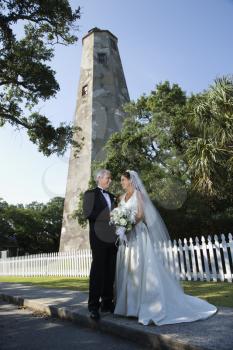 Royalty Free Photo of a Bride and Groom Standing Near a Lighthouse 