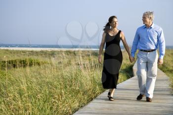 Royalty Free Photo of a Couple Holding Hands and Walking on a Walkway