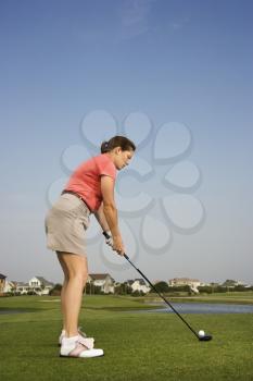 Royalty Free Photo of a Woman Preparing to Drive a Golf Ball