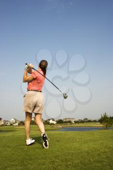 Royalty Free Photo of the Back View of a Woman Swinging a Golf Club