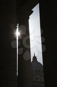 Royalty Free Photo of Sun Peeking Through Doric Columns in Saint Peter's Square in Vatican City, Italy