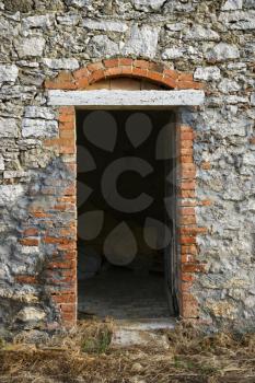 Royalty Free Photo of an Open Doorway Leading into an Old Stone Building in Tuscany, Italy.