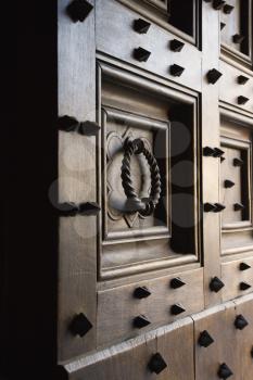 Royalty Free Photo of a Wooden Door With Metal Spikes and Knocker