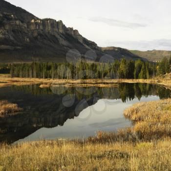 Royalty Free Photo of Wyoming Mountains Reflected in a Lake Surrounded by a Field