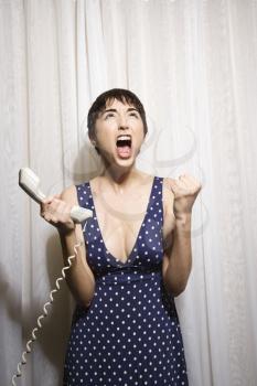 Royalty Free Photo of a Woman Holding a Telephone Receiver and Screaming