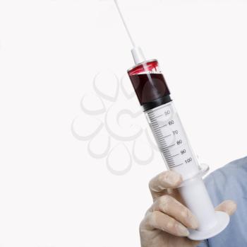Royalty Free Photo of a Man Wearing a Latex Medical Glove and Holding a Syringe