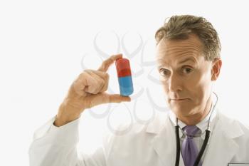 Royalty Free Photo of a Male Doctor Holding an Over Sized Medical Pill