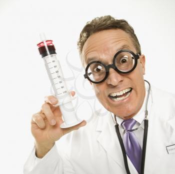 Royalty Free Photo of a Doctor Wearing Eyeglasses Holding an Over-sized Syringe