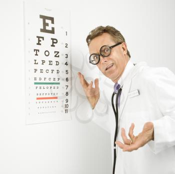 Royalty Free Photo of a Doctor Wearing Eyeglasses With an Eye Chart in the Background