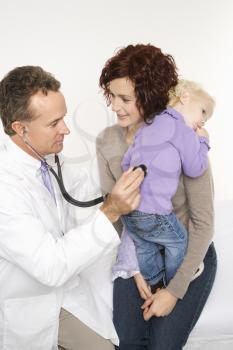 Royalty Free Photo of a Male Doctor Holding a Stethoscope to a Toddler's Back With Her Mother Watching