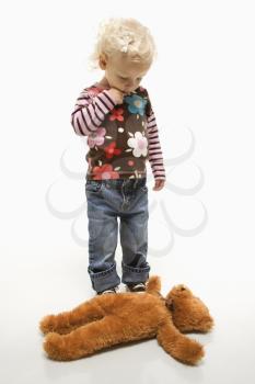 Royalty Free Photo of a Female Toddler Looking at Her Teddy Bear on the Ground