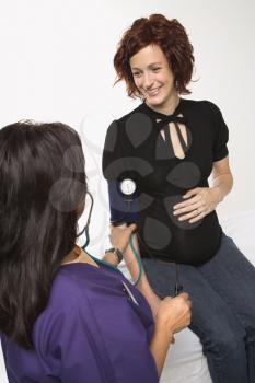 Royalty Free Photo of a Pregnant Woman Having Her Blood Pressure Checked by a Nurse
