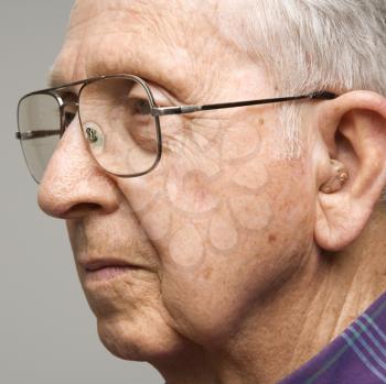 Royalty Free Photo of Close-up Profile Portrait of an Elderly Man With Glasses and a Hearing Aid