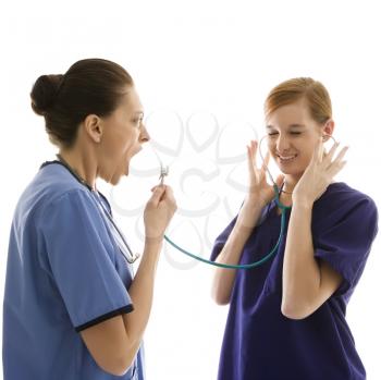 Royalty Free Photo of Health Care Workers Wearing Scrubs While Yelling into a Stethoscope