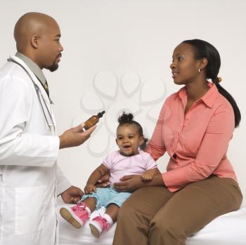 Royalty Free Photo of a Pediatrician Explaining Medication to a Mother and Her Daughter
