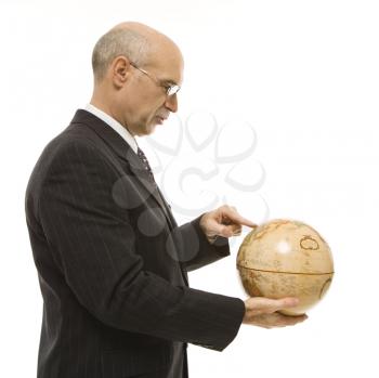 Royalty Free Photo of a Businessman Pointing on a Globe