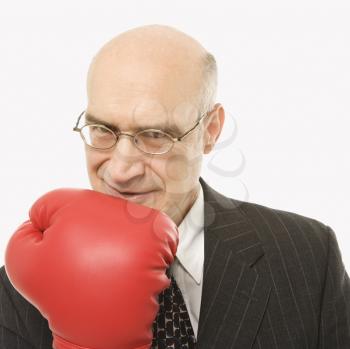 Royalty Free Photo of a Businessman Holding Up His Arm While Wearing Boxing Gloves
