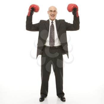 Royalty Free Photo of a Businessman Holding Up His Arms While Wearing Boxing Gloves