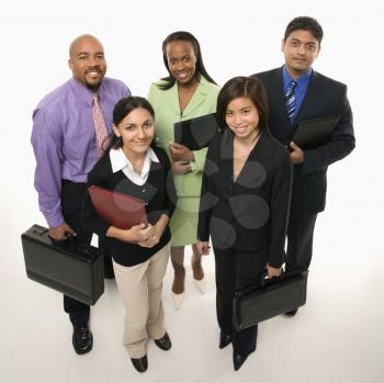 Portrait of multi-ethnic business group standing holding briefcases and looking at viewer.