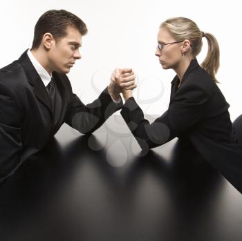 Royalty Free Photo of a Businessman and Businesswoman Arm Wrestling on a Table