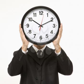 Royalty Free Photo of a Man Wearing a Suit and Holding a Clock in Front of His Face