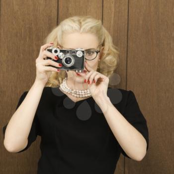 Royalty Free Photo of a Woman Holding a a Vintage Camera Up to Her Face