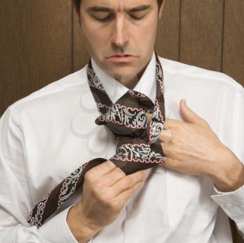 Royalty Free Photo of a Caucasian Male Tying His Necktie