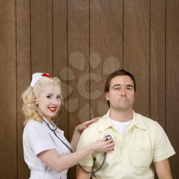 Royalty Free Photo of a Nurse  Checking a Male's Heartbeat 
