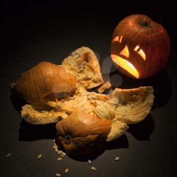 Royalty Free Photo of an Upset Jack-o'-Lantern Looking at a Smashed Pumpkin